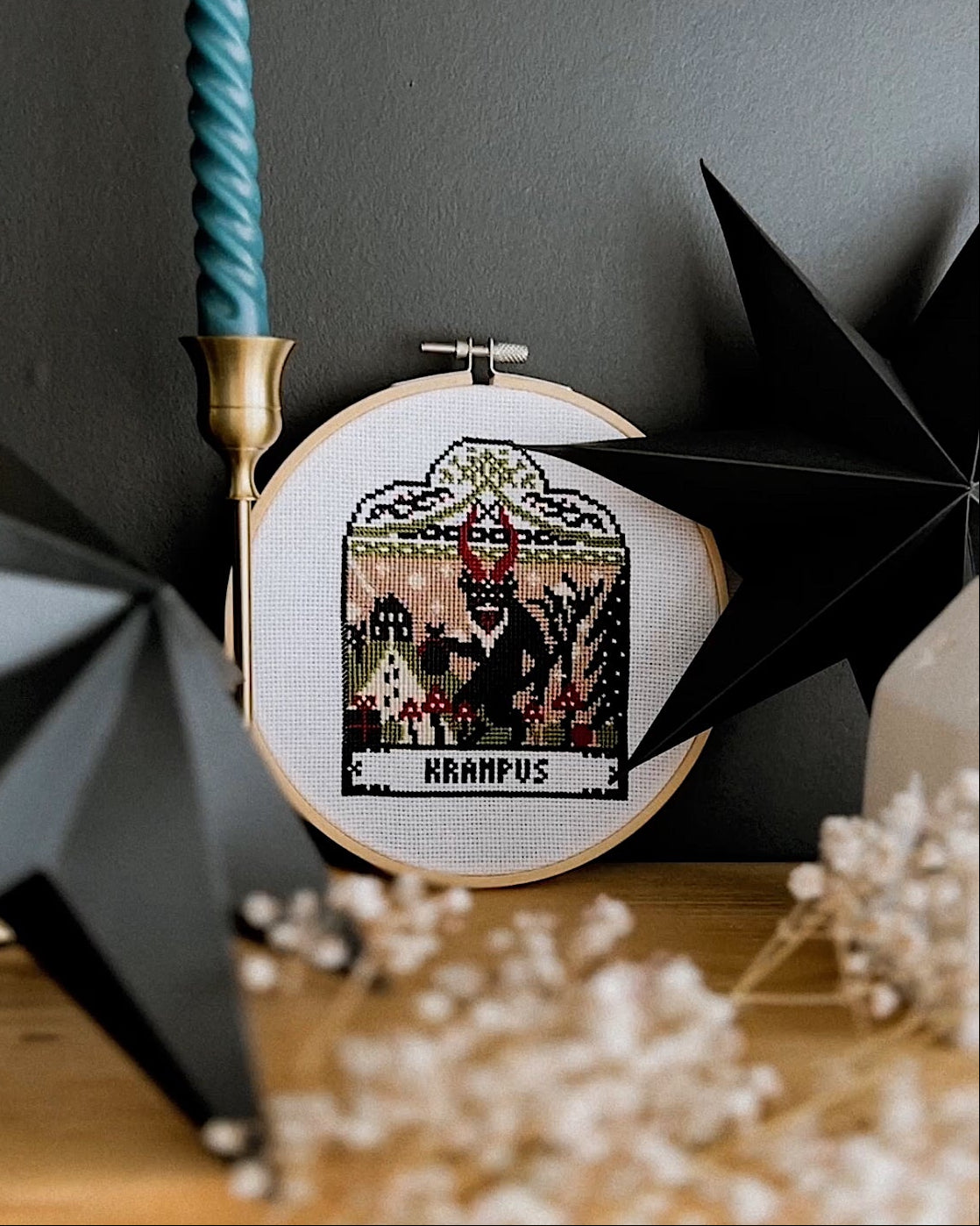 Embroidery hoop with Krampus design against a dark background
