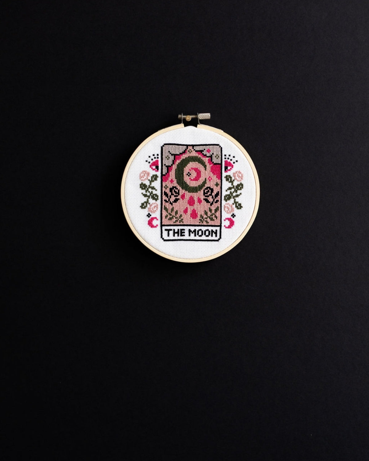 The moon tarot cross stitch design on a black background